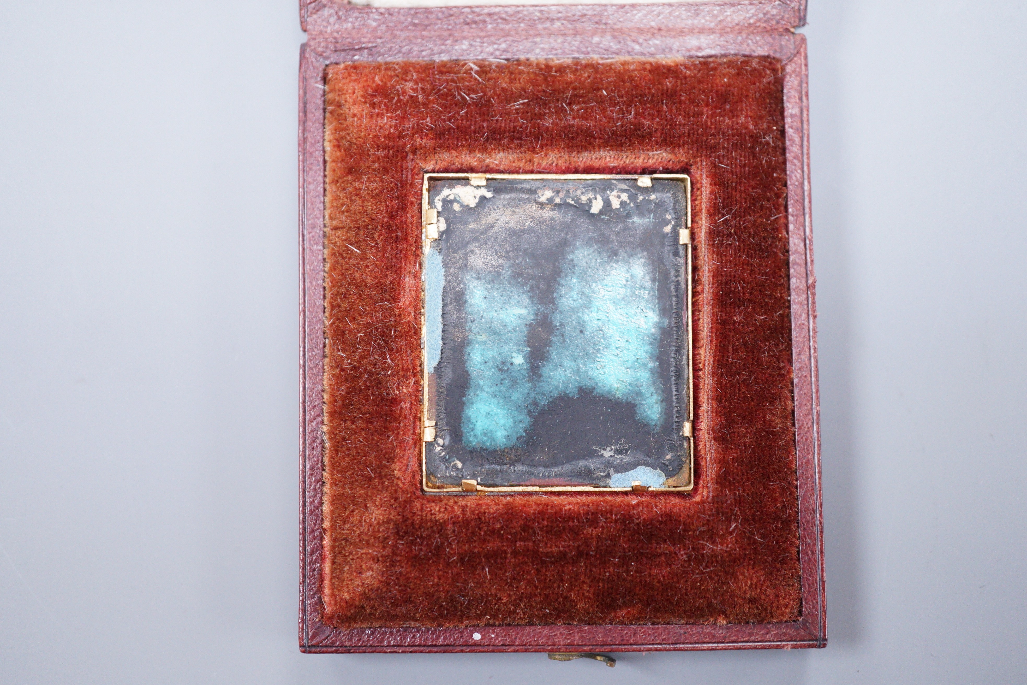 J. Roth, a gold framed enamelled miniature portrait of a gentleman with lace collar, signed 3.5 x 3cm, in fitted leather case